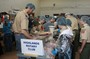 Scouts and Rotary members at work packing food for Haiti.